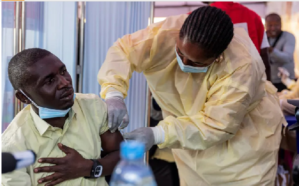 A Congolese health official administers an mpox vaccination to a man