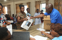 A female teacher receiving one of the government laptops from an official