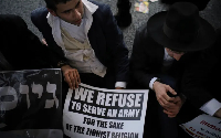 Ultra-Orthodox Jewish men block a highway during a protest against army recruitment