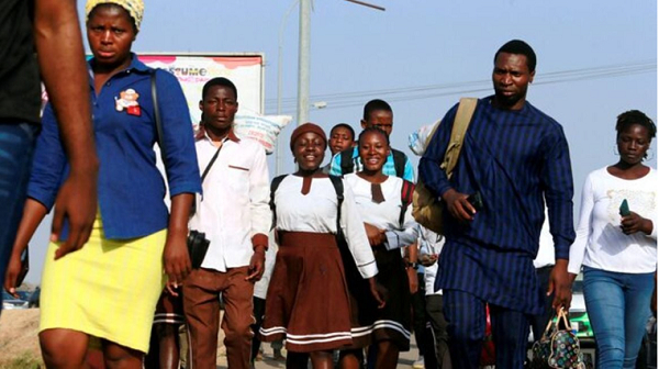 Students walk on a crowded sidewalk due to scarcity of local transport following shortage of petrol