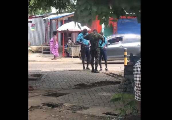 One of the military men assisting the students to dress properly
