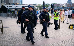 Armed police carrying assault rifles patrol outside the Sydney Opera House