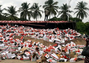 Packages of tinned tomatoes and spaghetti scattered on the road after truck overturns