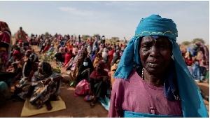 A Sudanese refugee who is seeking refuge in Chad waits with other refugees to receive food