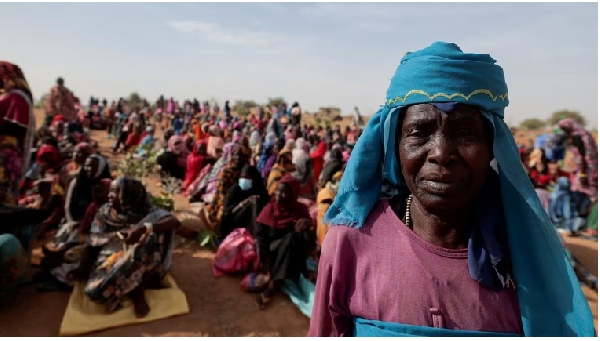 A Sudanese refugee who is seeking refuge in Chad waits with other refugees to receive food