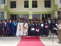Some graduates in a group photo with dignitaries
