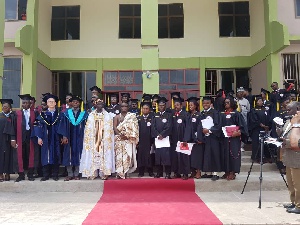 Some graduates in a group photo with dignitaries