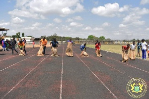 Some men and women in a sack race contest