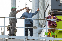 President Mahama (M) is shown something in a distance by Kwame Awuah Darko (L)