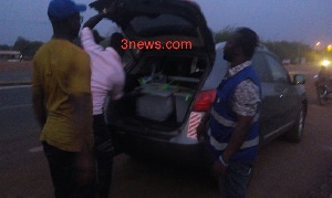 The ballot boxes being put in the booth of the car by the electoral officers.