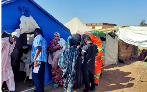 Sudanese  who fled escalating violence in the eastern-central al-Jazira state stand outside a camp