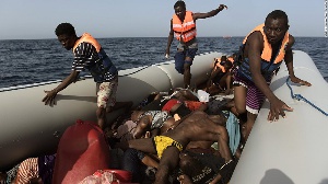 Migrants step over dead bodies while being rescued in the Mediterranean Sea, off the coast
