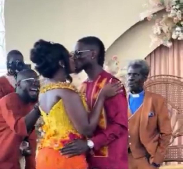 Gideon Mensah kissing his wife during the ceremony