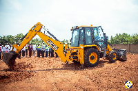 Rev. Dr. Wengam (in the Back Hoe assisted by Mr. Kutortse) to perform the sod cutting