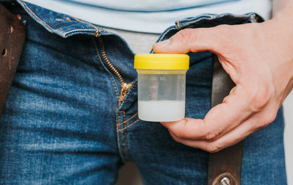 File photo of a man holding a container filled with semen - photo credit: Istock