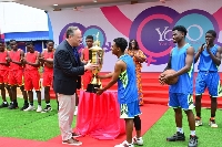 Douglas Emhoff presenting a trophy to a student during an interschools basketball competition