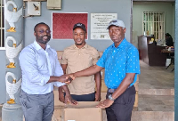 Treasurer of the Ghana Golf Association, Rodney Oddoye (R) receiving the items