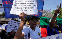 Eswatini pro-democracy activists hold placards during a protest outside the US Embassy in Pretoria