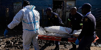 Police officers carry the body of a person on a stretcher after a mass shooting