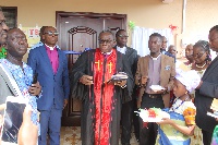 Apostle Richard Buafor [in cassock] being assisted by others to dedicate the clinic