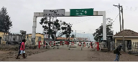 People walk past the Congo side of the Poids Lourd checkpoint at the border between Congo and Rwanda