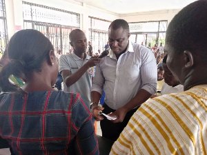 An electoral officer (speaking into the microphone) announcing the results after the polls