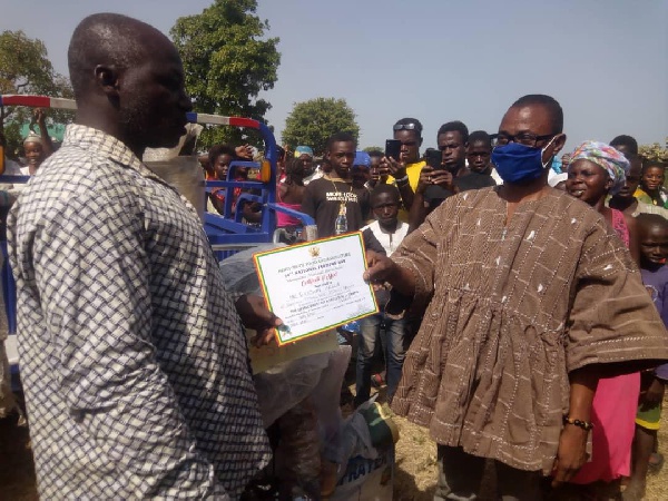 Moses Jotie, Wa East DCE, handing over the award to the best farmer