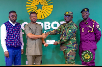 Sammy Gyamfi in brown (attire) hands over cheque to NAIMOS representatives