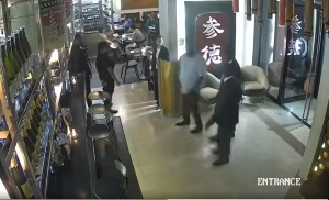 The video footage shows the entrance of the restaurant with three men entering