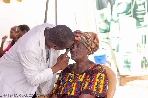 An old woman getting her eye checked by a doctor