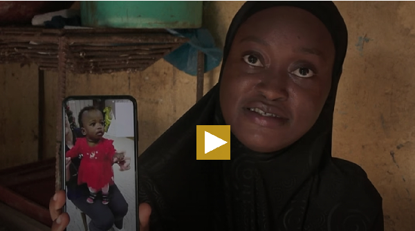 Mariam Soumah showing a photo of her daughter Sabina, who remains in Belarus