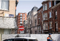 Police stand near a fence as they secure an area after a blast near a synagogue in Liège, Belgium