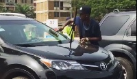 Musician Dadie Opanka cleaning car screens