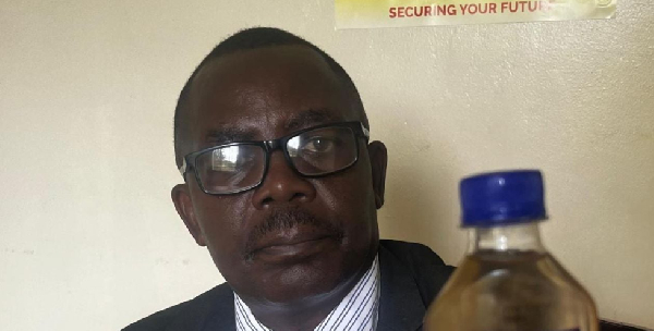 Kitagwenda RDC, Isaiah Byarugaba Kanyanahane showing reporters a bottle of an untaxed alcohol