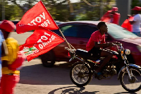 A motorcyclist with flags of the Mozambique Liberation Front (Frelimo) party arrives at a rally in B