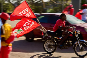 A motorcyclist with flags of the Mozambique Liberation Front (Frelimo) party arrives at a rally in B