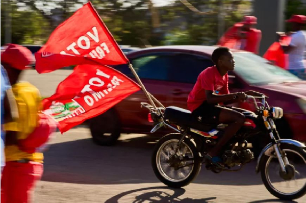 A motorcyclist with flags of the Mozambique Liberation Front (Frelimo) party arrives at a rally in B