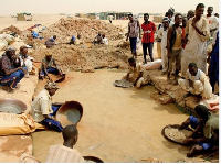 Sudanese men pan for gold