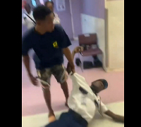 The security guard lying unconscious while the suspect continued to assault him