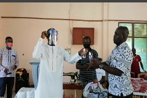Kwasi Bonzoh presenting items to one of the Senior High Schools