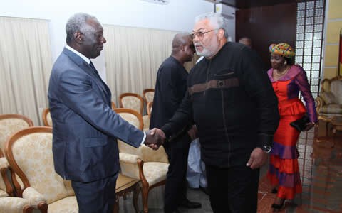 Former President Rawlings in a handshake with Former President Kufuor