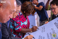 Minister of Trade Elizabeth Ofosu-Adjare signing the agreement
