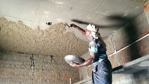 Man plastering the building under construction