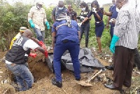 File Image of a Pathologist and Police examining a body that was buried after the deceased was murde