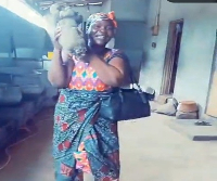 The food vendor holding a tuber of yam