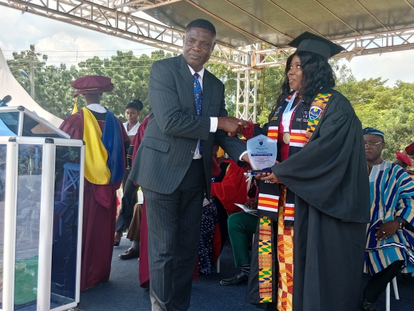 One of the graduating students with her award