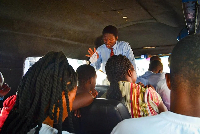 A preacher stretches out his hand to pray for passengers in a trotro