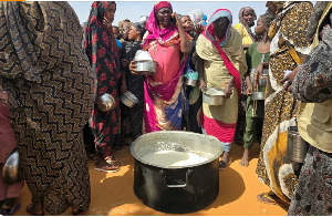 Women gather for a meal in al-Rahmaniyah camp for displaced people