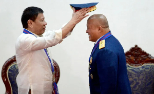 Ex-Philippine President Rodrigo Duterte puts a hat on then PNP chief Ronald ‘Bato’ Dela Rosa