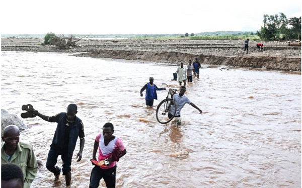 People wade through floodwaters in the aftermath of Tropical Cyclone Freddy southern Malawi
